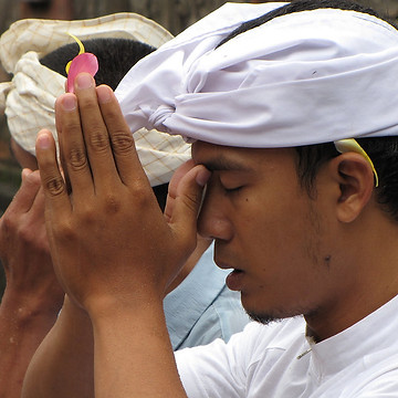 A person praying with his hands together
Description automatically generated